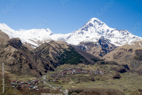panorama of Kazbek mountain village meadow and snow