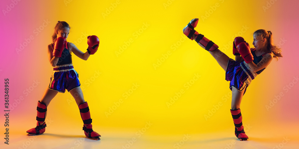 Little caucasian girl, kick boxer on gradient background in neon light, active and expressive. Concept of motion, action, motivation. Training winner, emotional. Sales, ad, flyer with copyspace.