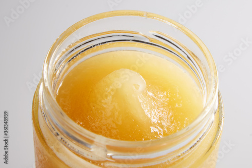 Beautiful macro image of honey in a jar from above. Appetizing golden drop of honey with a textured texture.