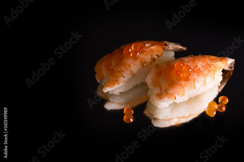 Sushi and role on the reflective surface, black background. concept of healthy traditional Japanese cuisine. selective focus.