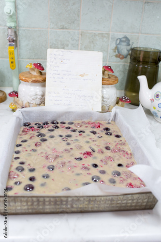 Preparation of cake with cherries and raspberries.
