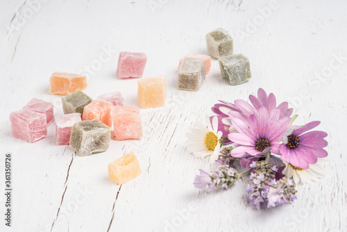 Turkish delights and spring flowers on a table with copy space