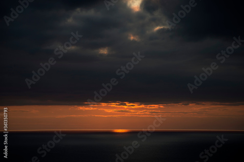 Fototapeta Naklejka Na Ścianę i Meble -  The sun sets behind the waves round the northern irish causeway coast