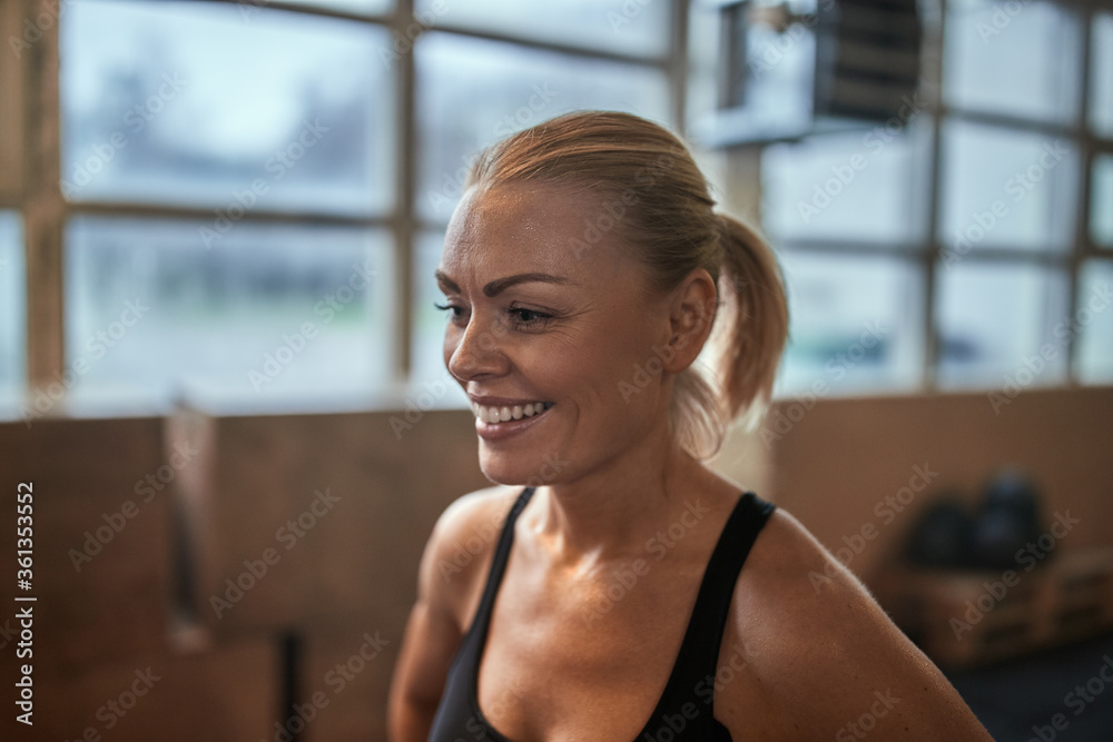 Smiling woman sweating after a workout at the gym