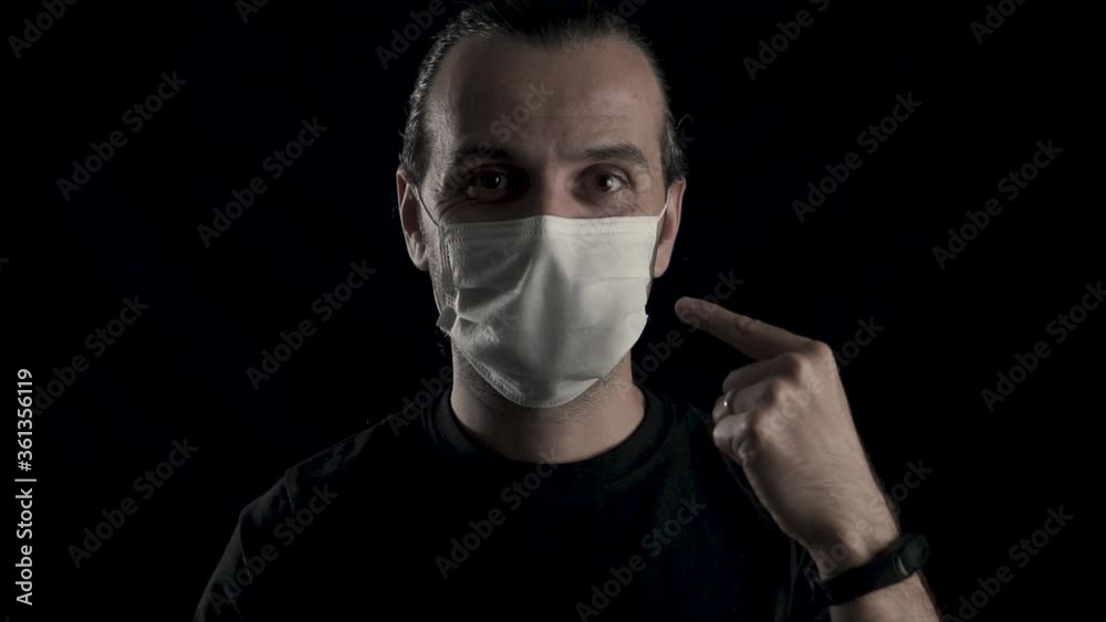 Young handsome man is approving face mask with hand gestures and smiling. Happy, health guy on black background, protecting himself from coronavirus. Young handsome man is approving face mask with hand gestures and smiling. Happy, health guy on black background, protecting himself from coronavirus.