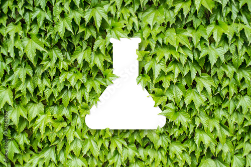 Test tube icon on green leaves background