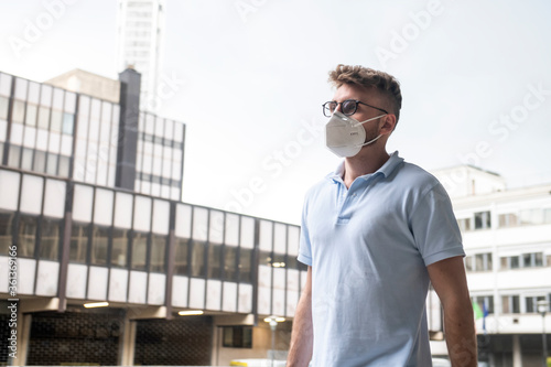 Young business man wearing a Covid-19 protective face mask while working in the business district area