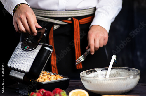 Man making waffles on a waffle machine