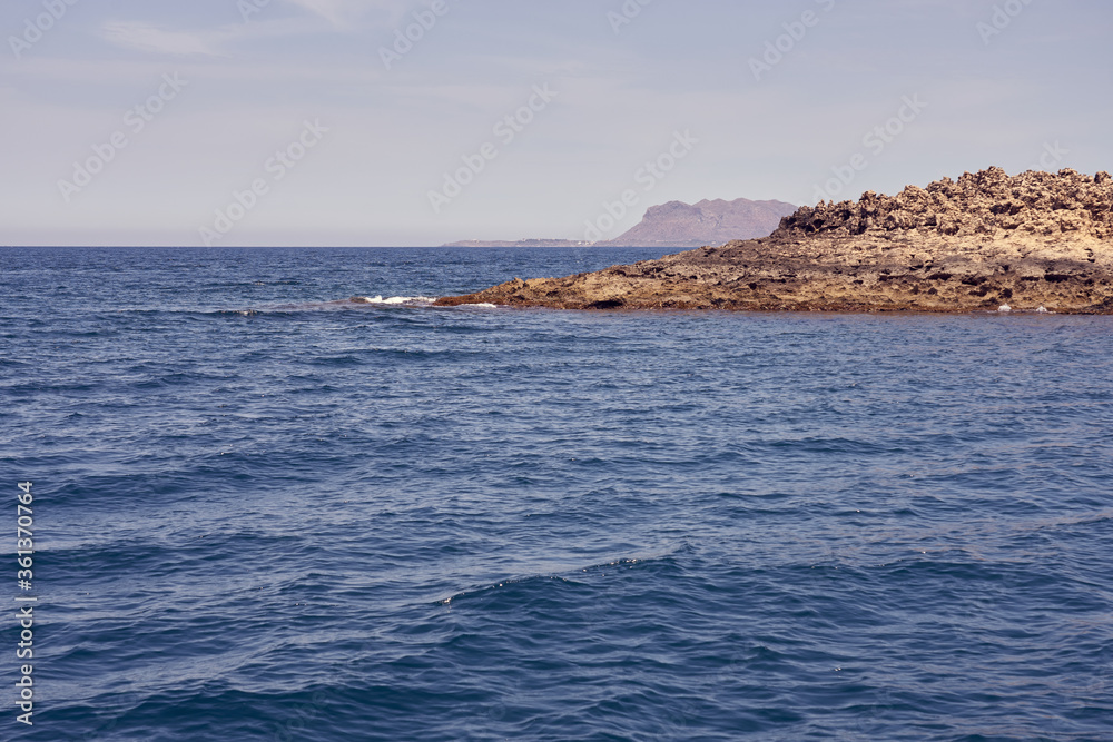 Rocky sea coast of Crete, Greece on a sunny day with clear sky. Rocky sea coast of Crete, Greece on a sunny day with clear sky.