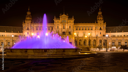 Purple Fountain - A wide-angle night view of the illuminated water fountain at the center of Spanish Square - Plaza de España, Seville. Andalusia, Spain.