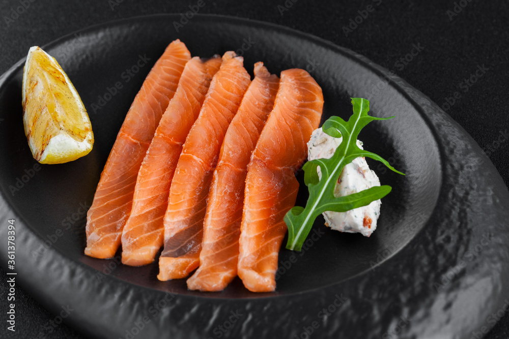 Freshly salted sliced salmon with lemon and curd cheese on plate Freshly salted sliced salmon with lemon and curd cheese on plate