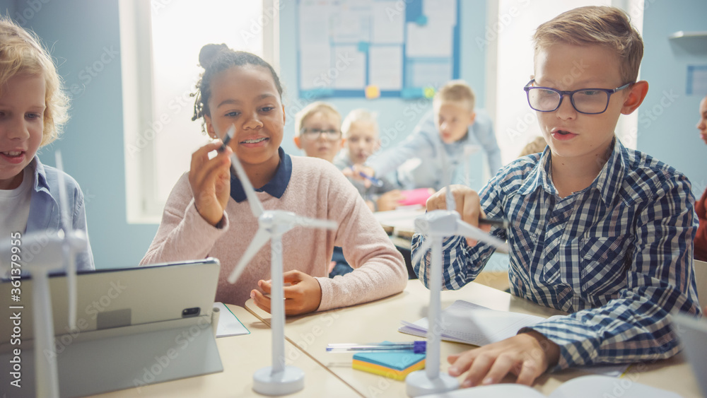 Obraz premium In the Elementary School: Class of Brilliant Young Children Work as a Team Using Tablet Computers to Program Wind Turbines. Classroom with Kids Learning about Eco-Friendly Forms of Renewable Energy