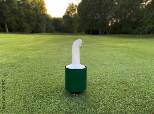Valokuva A mixture of sand and grass seed are in a container, that is sitting in the middle of a fairway