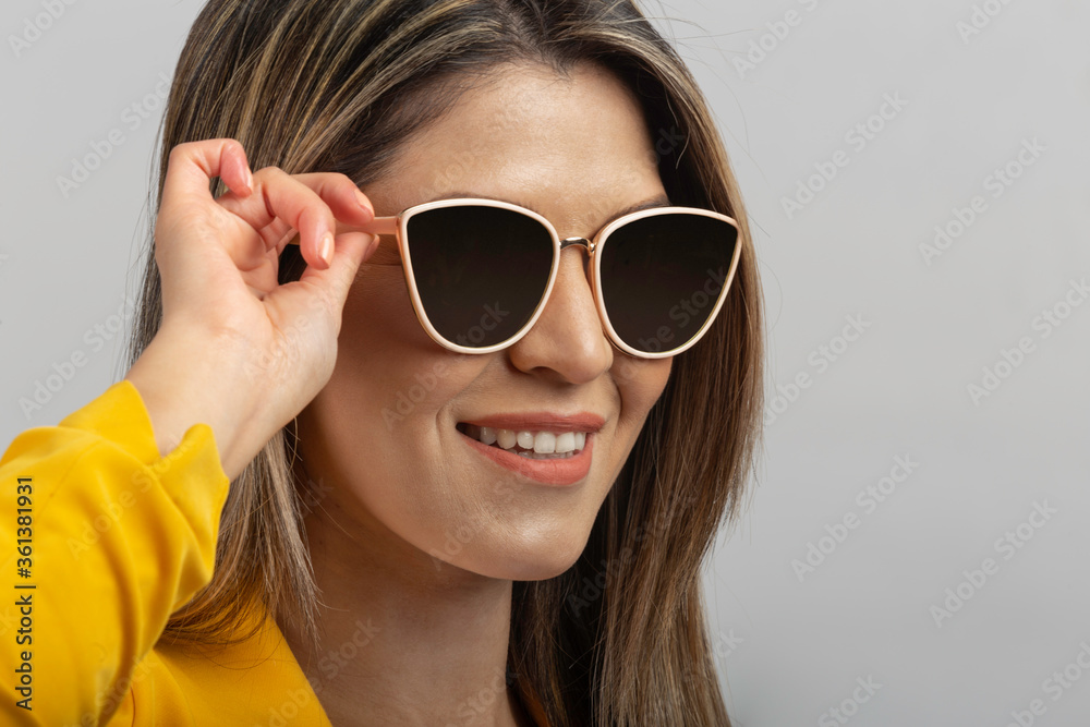 close up of latin woman face with blond hair taking his sunglasses, studio close up of latin woman face with blond hair taking his sunglasses, studio
