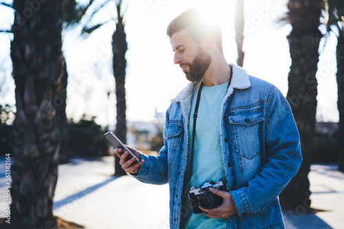 Photography Handsome male tourist dressed in casual trendy outfit using cellular calling tax