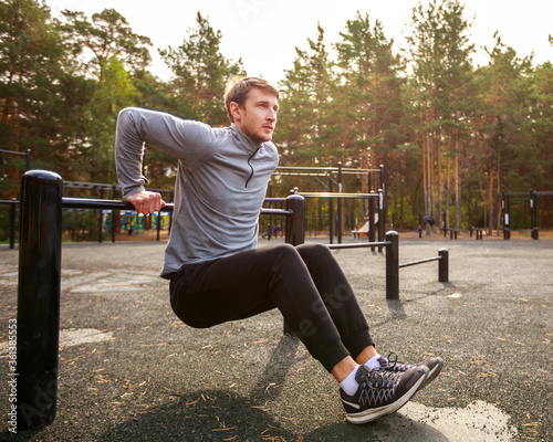Young sports athlete fitness. Exercise Parallel Bars Outdor. Sport, workout, gym, exercising, training and lifestyle concept.