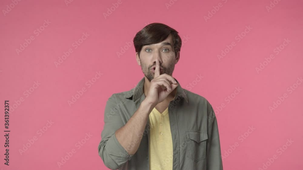 Handsome bearded man asking keep promise and secret safe, shushing with finger pressed to lips, make hush shh sign to tell be quiet or silent, dont speak its taboo, pink background Handsome bearded man asking keep promise and secret safe, shushing with finger pressed to lips, make hush shh sign to tell be quiet or silent, dont speak its taboo, pink background