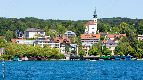 View on the town of Starnberg with lake Starnberger See in the foreground. With colorful boat houses and church St. Josef. photo