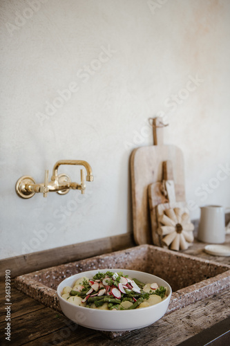 Frischer Salat in rustikaler Küche mit Vintagemöbeln und Messing-Armatur photo