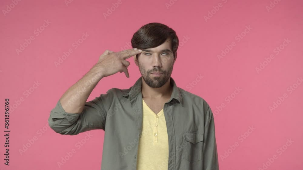 So lame and uninteresting. Handsome distressed and annoyed bearded man, put hand over temple make gun pistol gesture and shooting himself, eye roll bored and bothered, pink background So lame and uninteresting. Handsome distressed and annoyed bearded man, put hand over temple make gun pistol gesture and shooting himself, eye roll bored and bothered, pink background