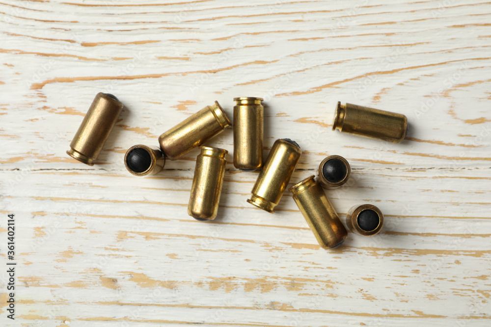Rubber bullets on wooden background, top view. Self defense weapon