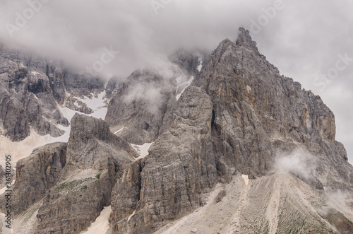 Pale di San Martino southern mountain chain of the Dolomites with Cimon della Palla & Cima Vezzana mountain peaks on a partly cloudy, misty day as seen from Baita Segantini refuge, Passo Role,Italy. photo