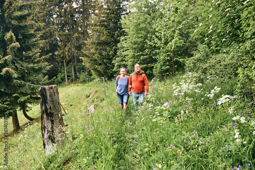 Middle age couple hiking in green forest, active family time © annanahabed
