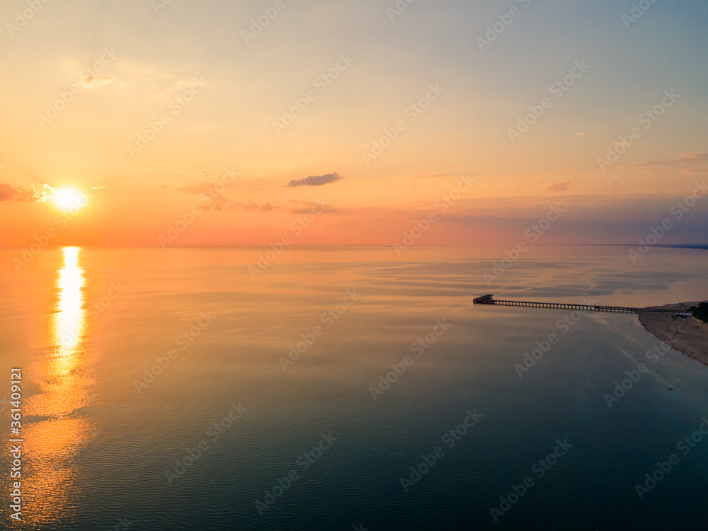 Naklejka premium Aerial view of sunset over the sea in Palanga, Lithuania. Sandy coastline with the bridge to the sea.