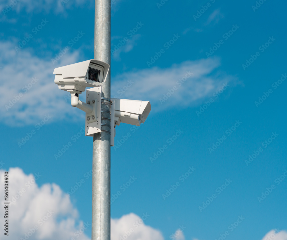 Security CCTV camera against blue sky