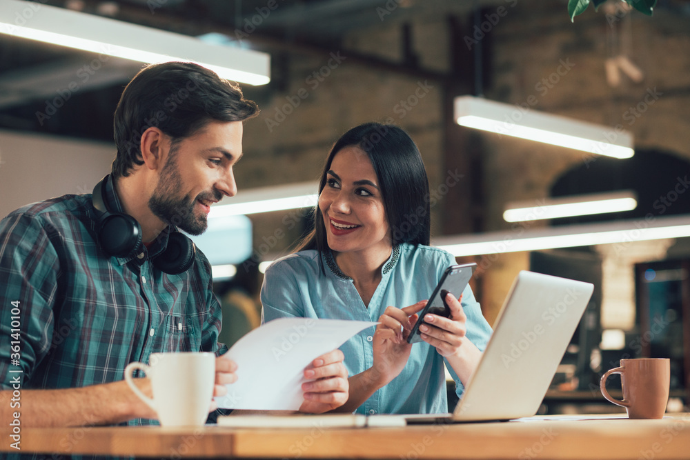 Friendly coworkers with modern gadgets sharing interesting ideas