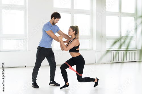 Young woman during workout with a personal fitness instructor in the gym