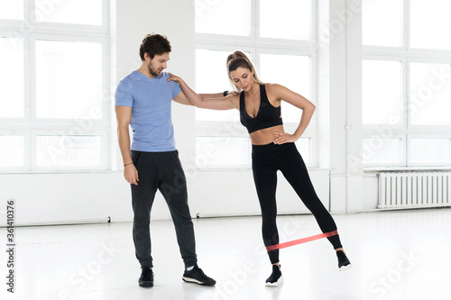 Young woman during workout with a personal fitness instructor in the gym