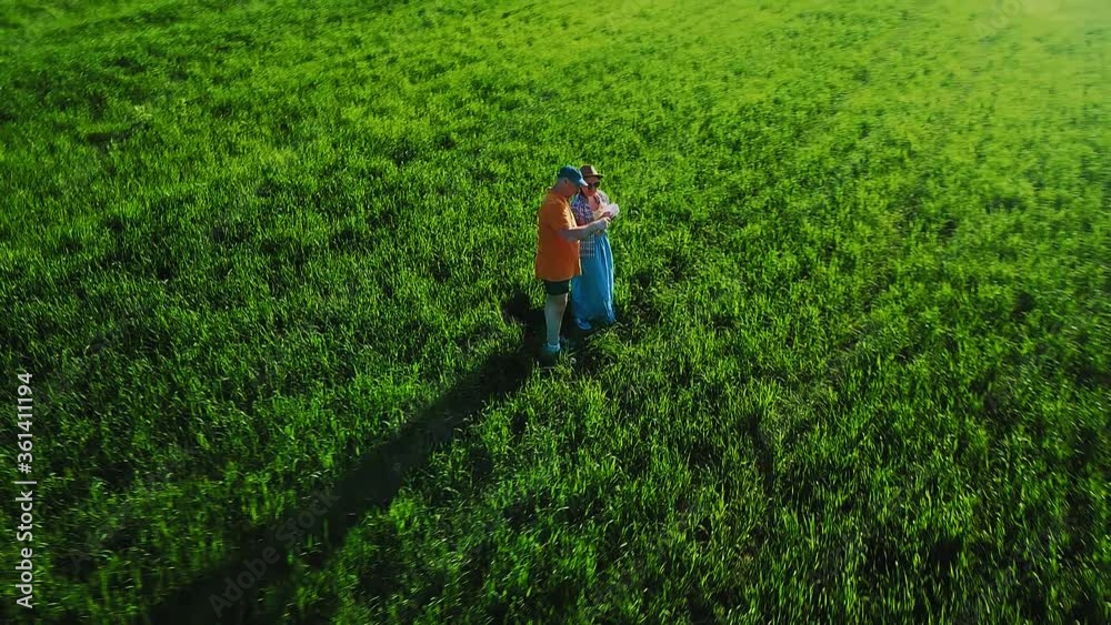 Agronomists a man and a woman in a field inspect crops of crops and record observations Agronomists a man and a woman in a field inspect crops of crops and record observations