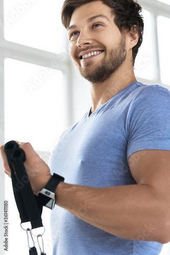 Young man during workout with a resistance bands in the gym