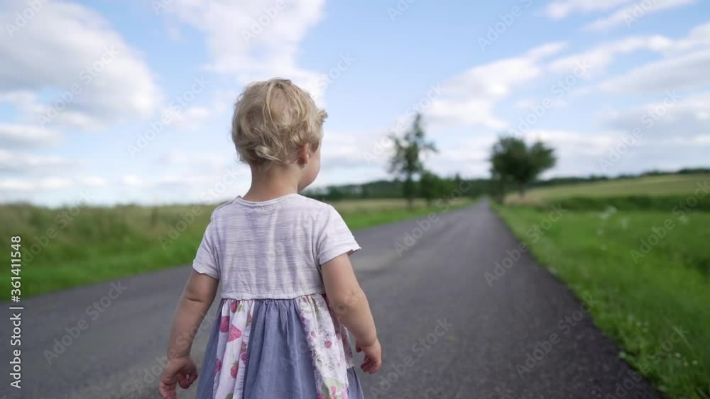 Baby girl walking on country road Baby girl walking on country road