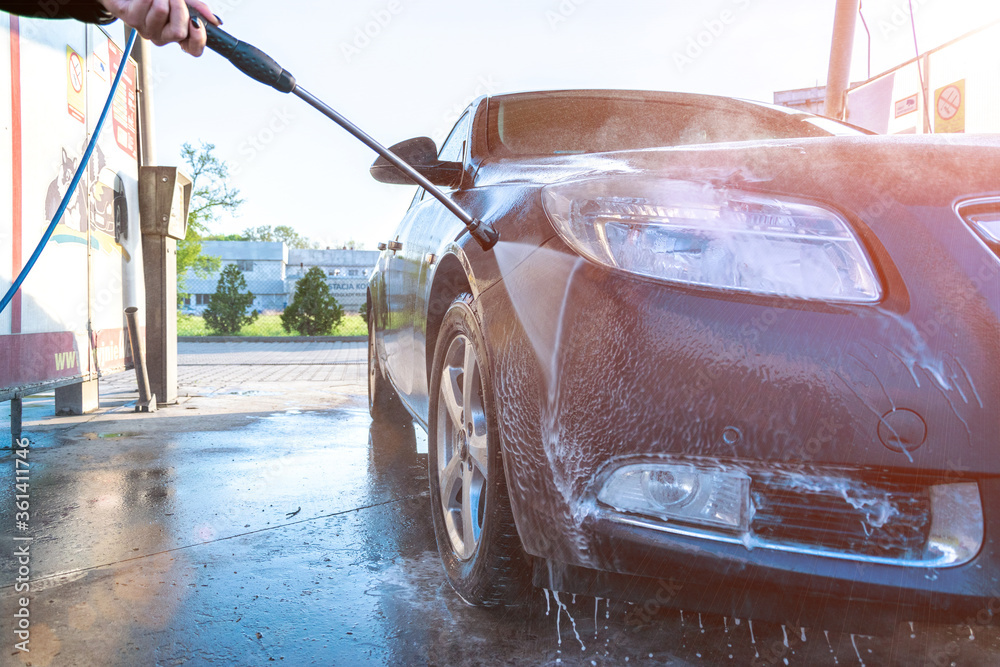Auto carwash clean station. Hand wash car with water, foam. Soap