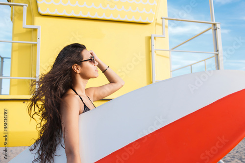 Photography Portrait of a young charming surfer female enjoying sun and free time after her