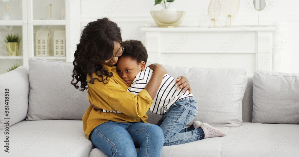 Portrait of African American woman hugging his cute little daughter. Little girl greeting her mother at home. Happy mother's day. Portrait of African American woman hugging his cute little daughter. Little girl greeting her mother at home. Happy mother's day.