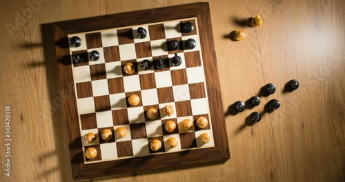 Top view time lapse or stop motion of a chess game under dramatic lighting.