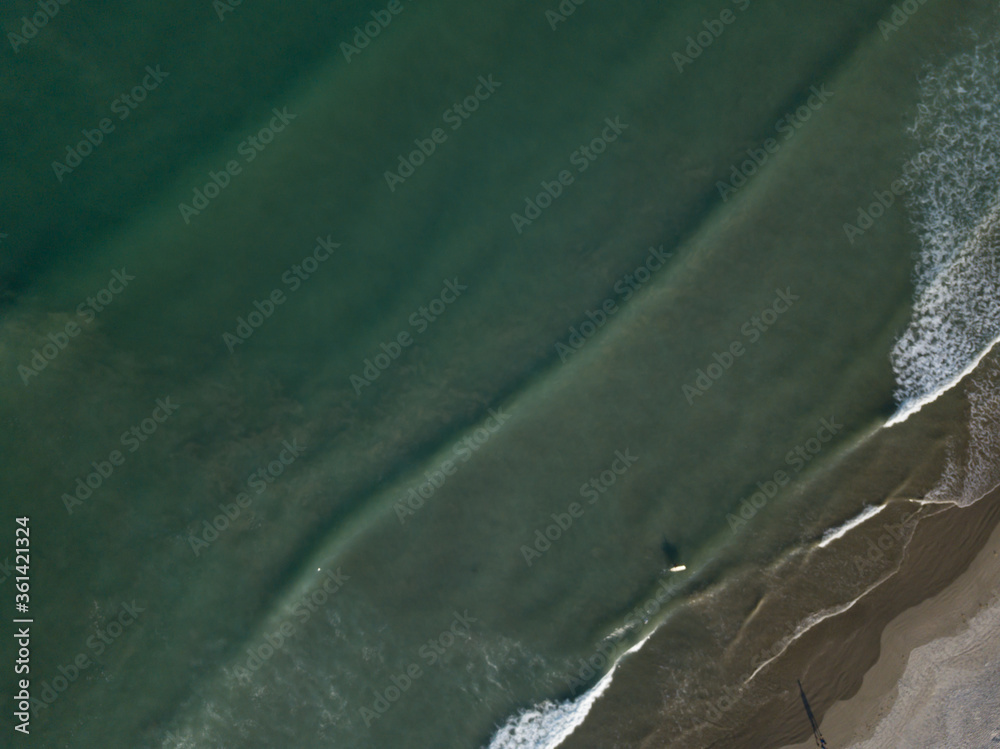 Aerial photo of waves breaking near a rural surf beach, New Zealand. 