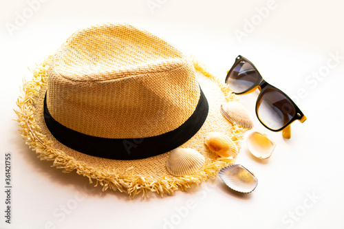 bright summer hat and sunglasses with shells.