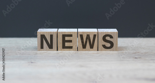 NEWS word concept written on wooden cubes blocks stand on a light table and light background