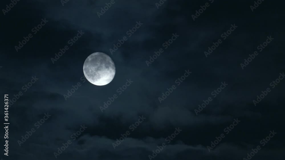 Dramatic night shot of a bright moon with a cloudy sky, the Netherlands.