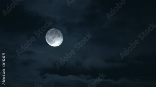 Dramatic night shot of a bright moon with a cloudy sky, the Netherlands.