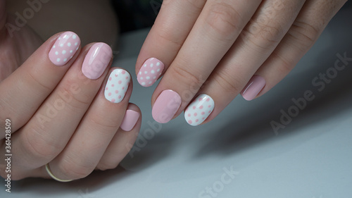 pink and white nail polish. Nail design with white dots on pink nail polish
