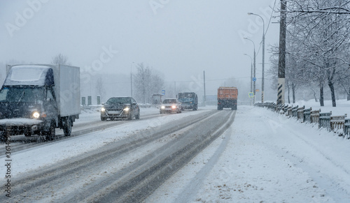 Heavy snow in the city, roadway with cars in the snow, ice.
