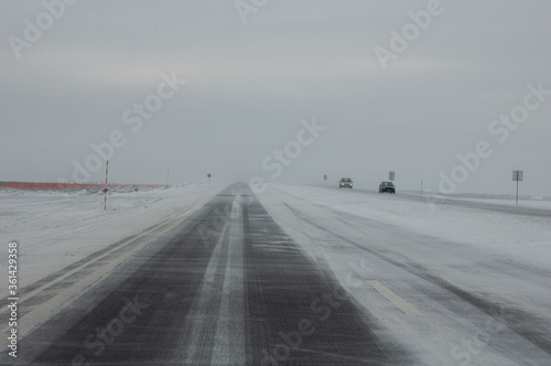 Direct winter road during heavy snow without cars.