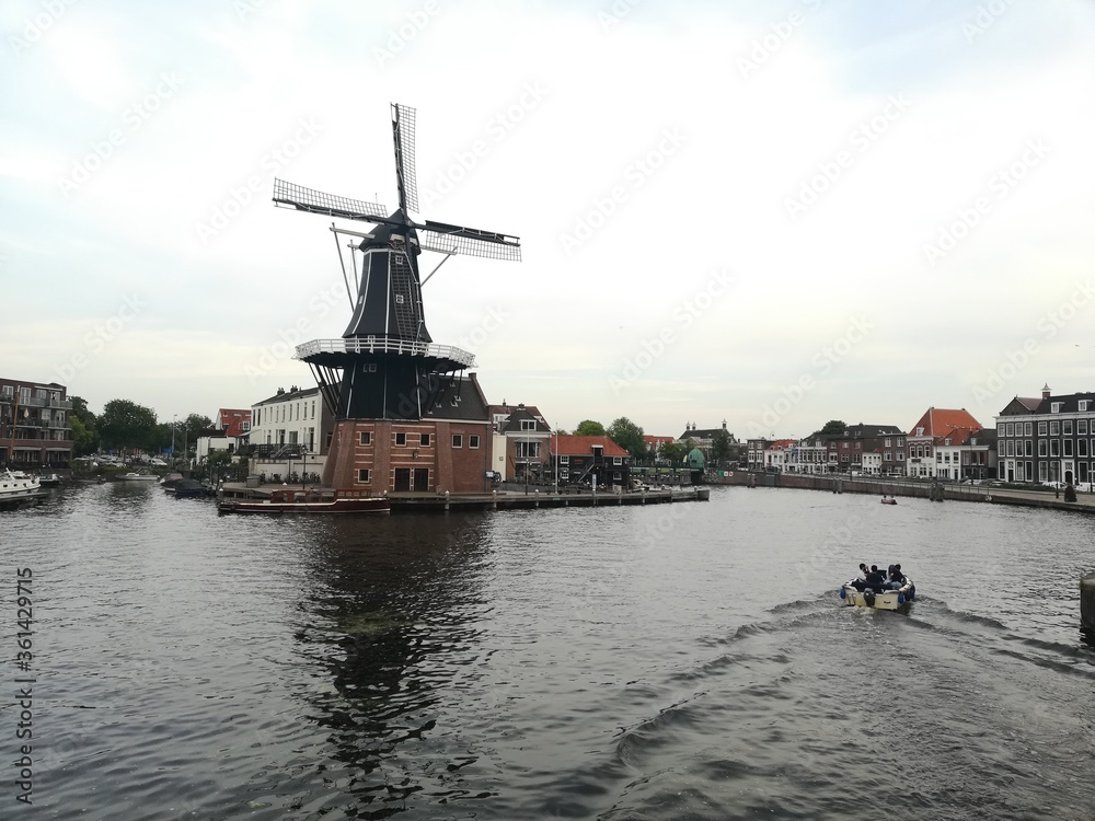 panorama photo view of windmill  behind big canal in holland Netherlands