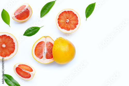 High vitamin C. Juicy grapefruit slices with green leaves on white background.