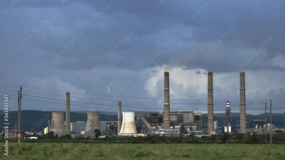 Time lapse of thermal power plant cooling towers and chimney stacks, with storm clouds behind them. CET Govora near Ramnicu Valcea, Romania. Time lapse of thermal power plant cooling towers and chimney stacks, with storm clouds behind them. CET Govora near Ramnicu Valcea, Romania.